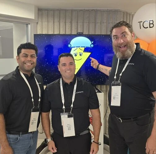 John with fellow summit participants beside a Lumen demonstration screen